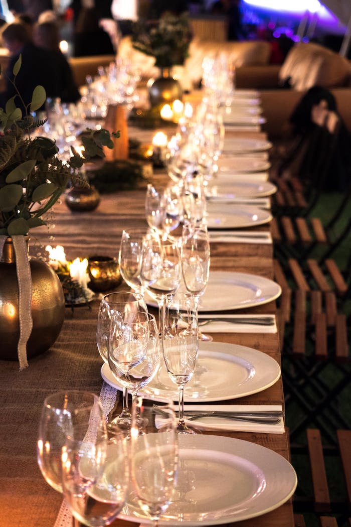 creative Beautifully arranged candlelit table with wine glasses and decor for an intimate event.