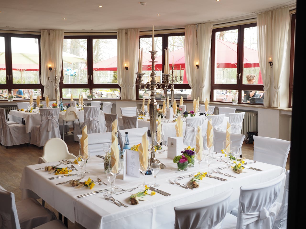 mobile-01 A beautifully arranged dining room with elegant table settings ready for a special event or celebration.