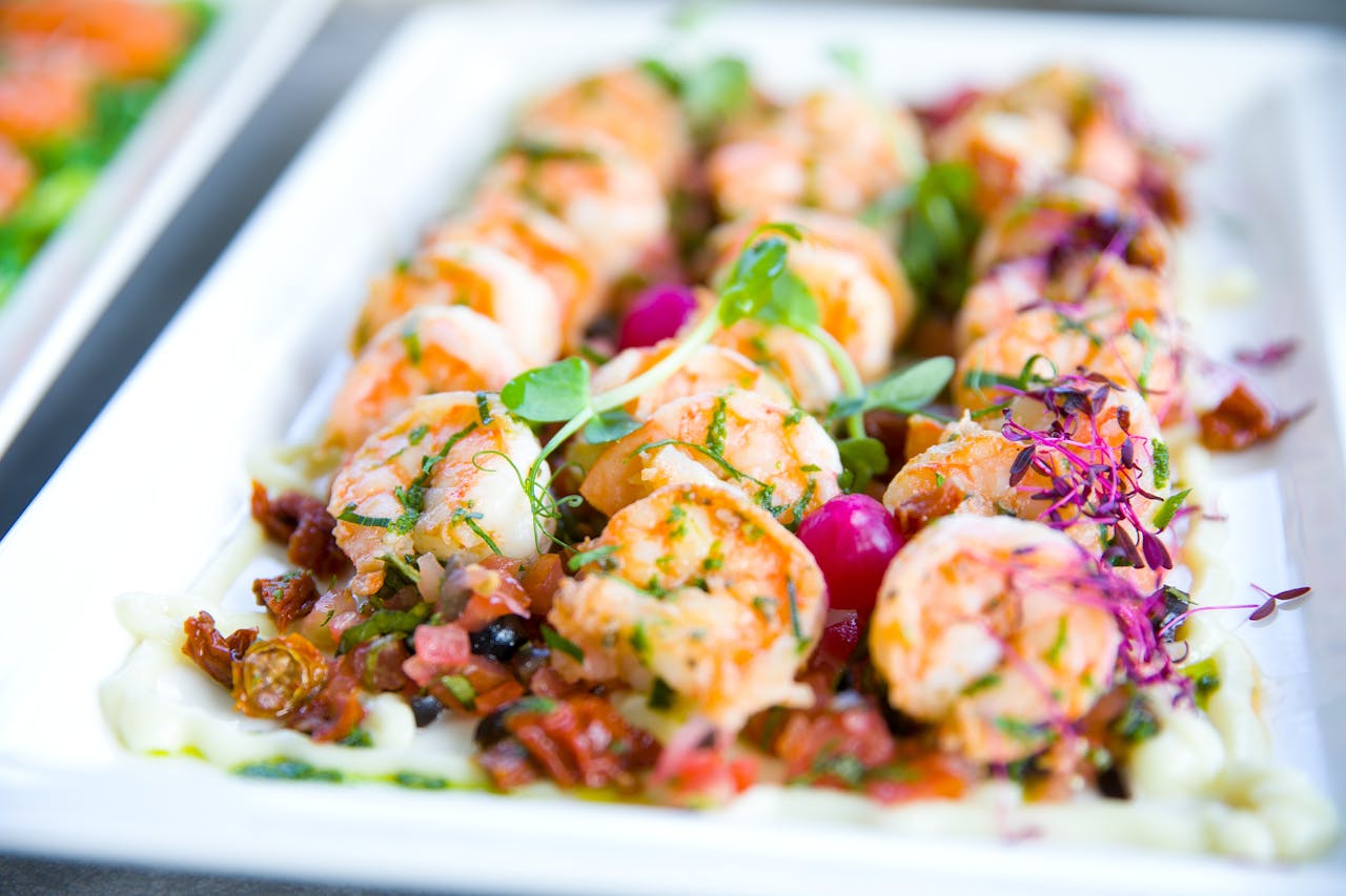 digital Closeup of delicious shrimps with vegetables and microgreens on white plate on catering table