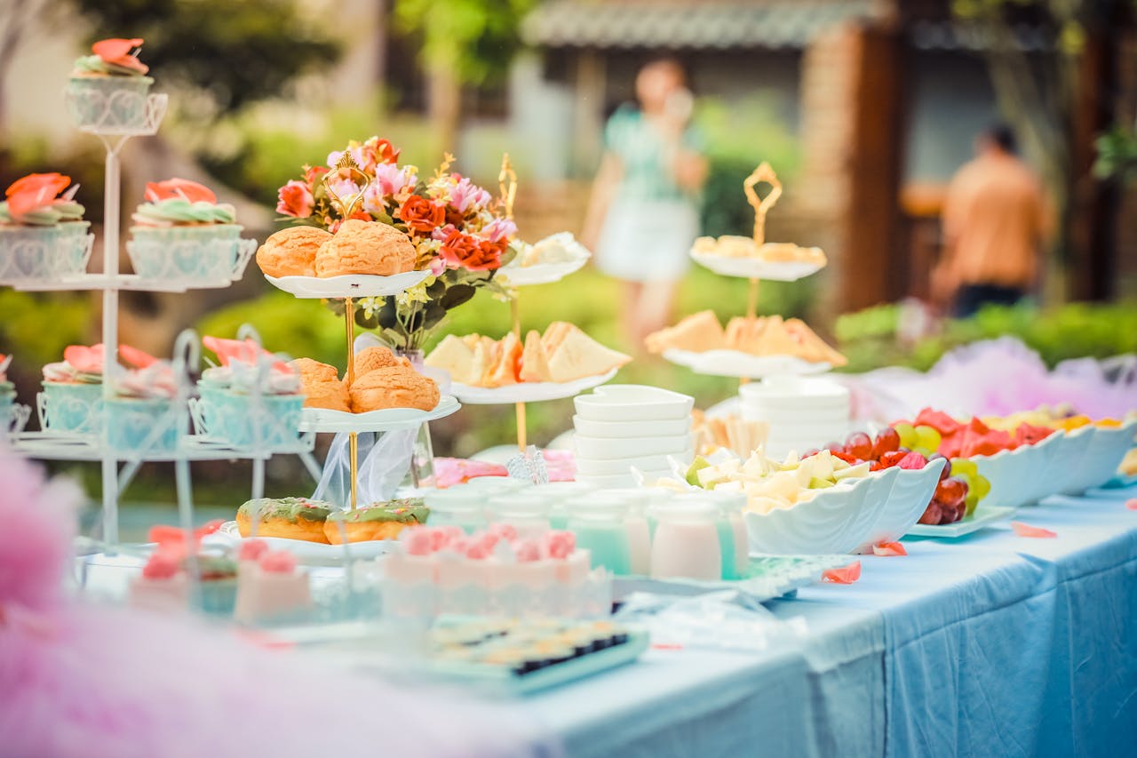Services-01 A vibrant outdoor buffet table showcasing an array of colorful pastries and fruits, perfect for parties.