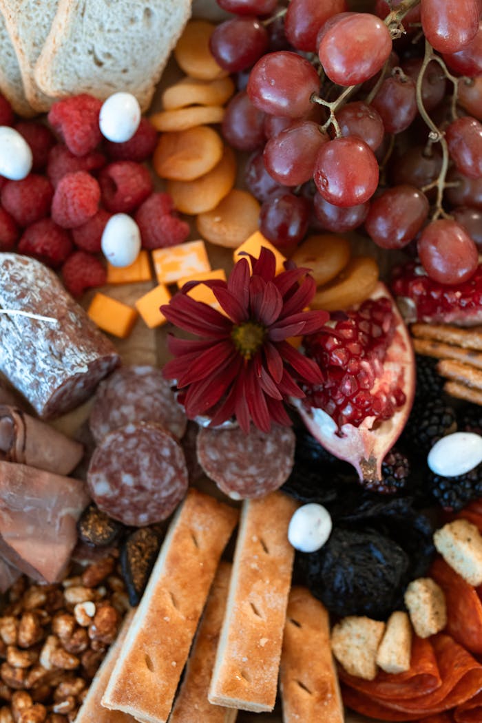 why-choose-us Artfully arranged charcuterie board featuring meats, cheeses, fruits, and nuts.